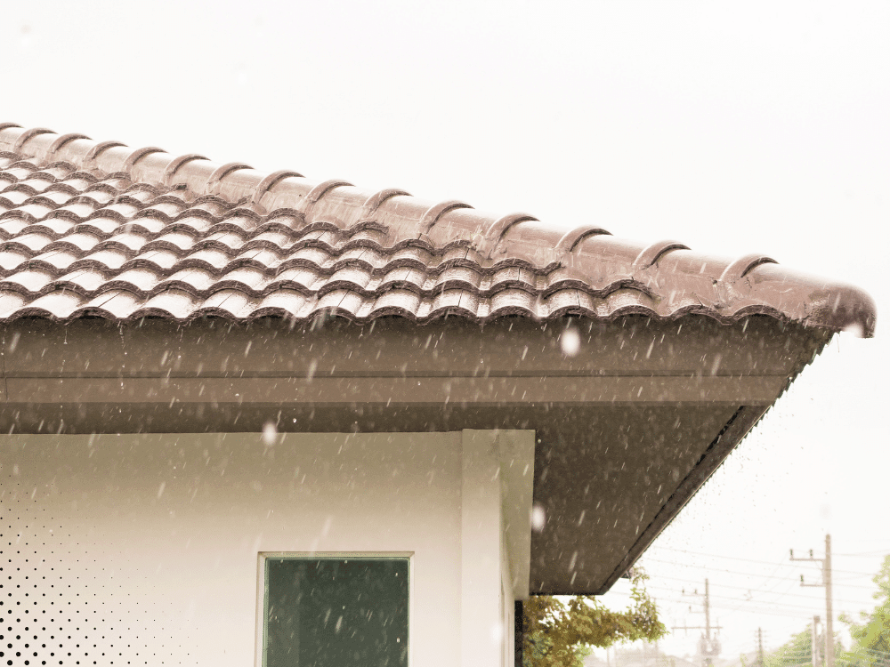 Residential tile roof exposed to heavy rainfall, demonstrating roof inspection importance for storm damage in Buford GA