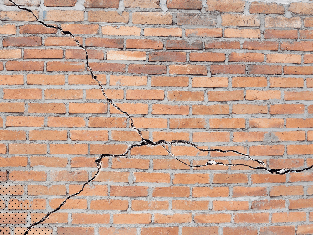 Foundation crack in brick wall showing structural movement and settlement issues in residential home